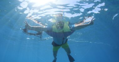 a man snorkeling in blue water