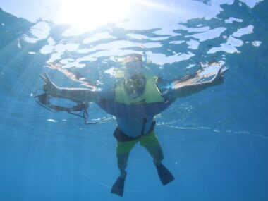 a man snorkeling in blue water