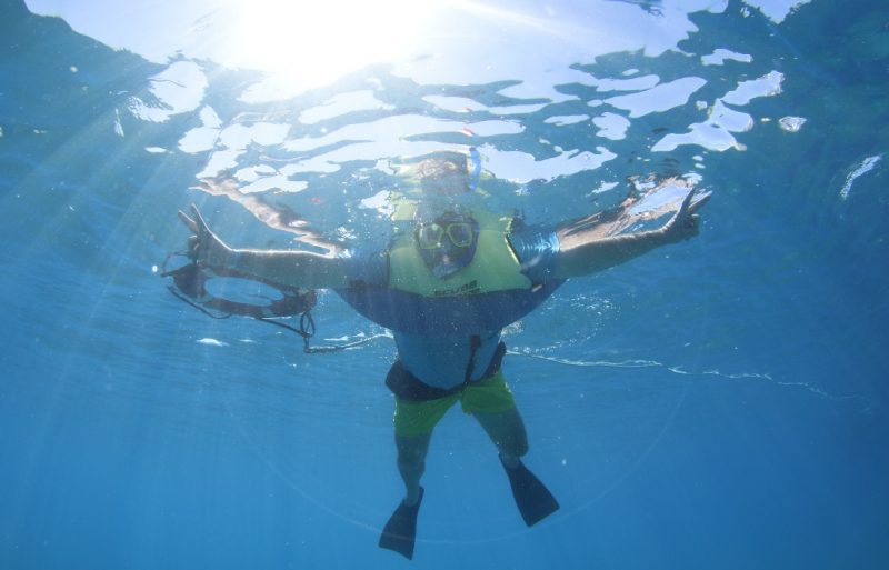 a man snorkeling in blue water