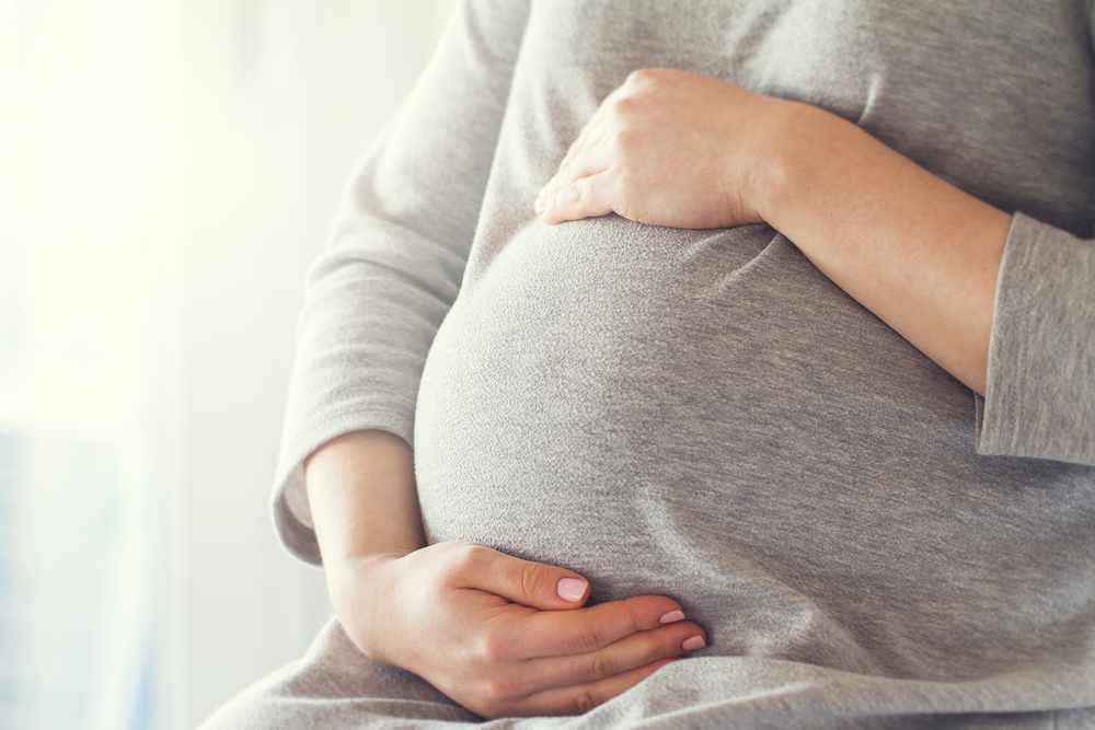 A pregnant woman holding her belly