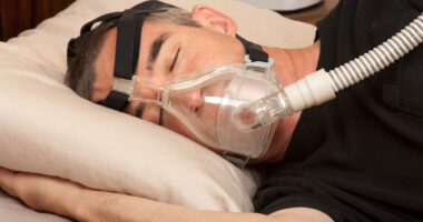 A man sleeping in a BiPAP machine.