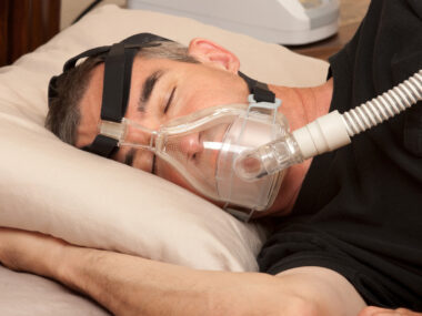 A man sleeping in a BiPAP machine.
