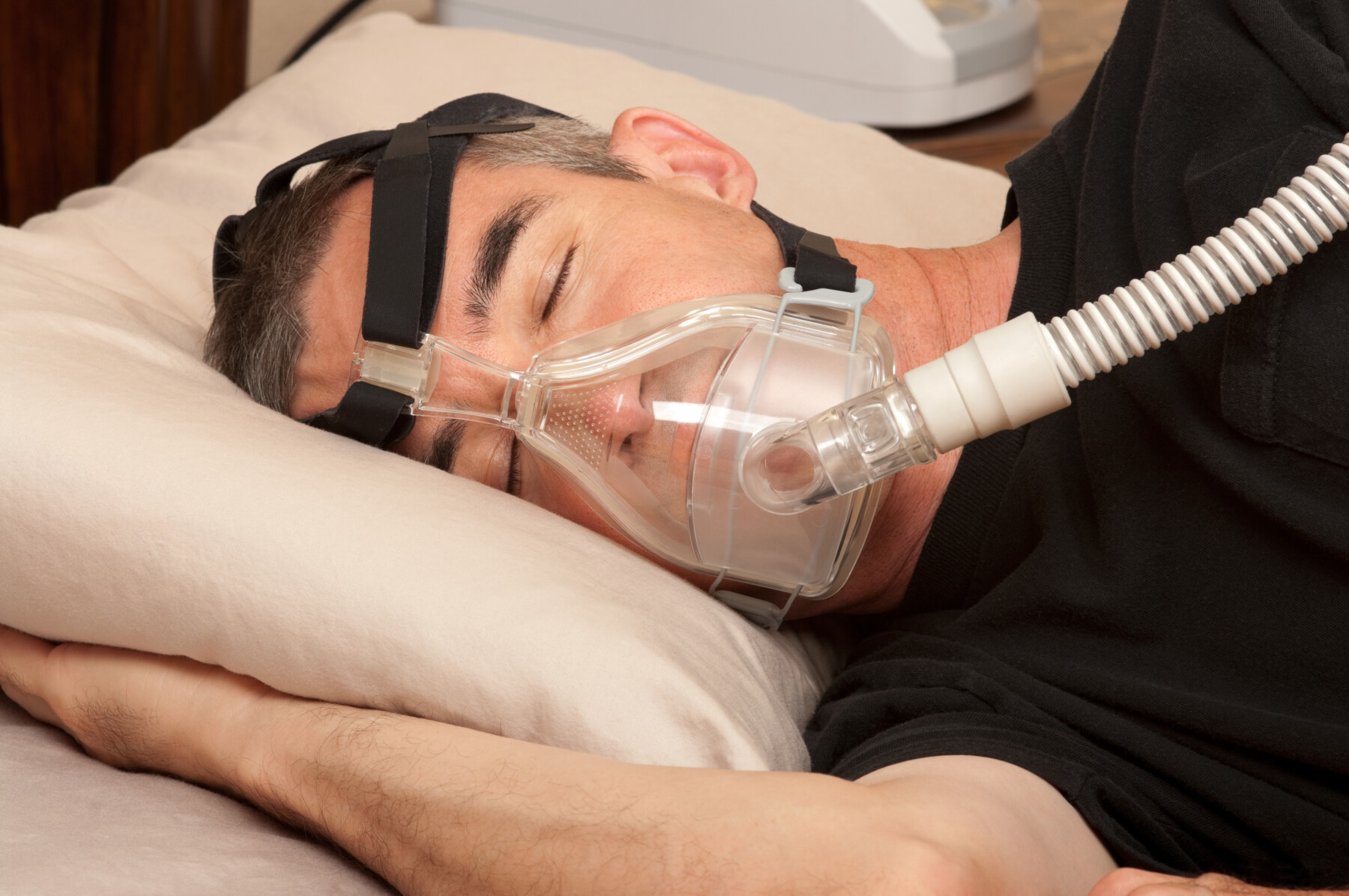 A man sleeping in a BiPAP machine.