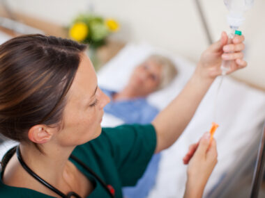 A healthcare provider preparing to give an infusion to a patient.