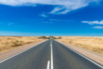 A road going off into the distance with blue sky.