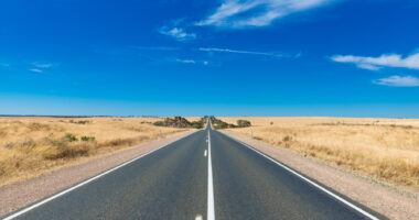 A road going off into the distance with blue sky.