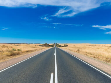 A road going off into the distance with blue sky.