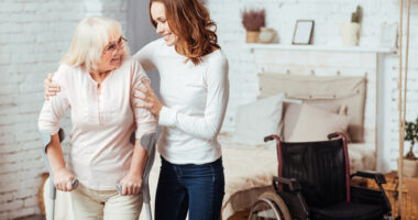 an occupational therapist helping a woman in her home with a wheelchair beside them