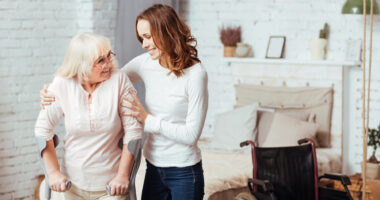 an occupational therapist helping a woman in her home with a wheelchair beside them