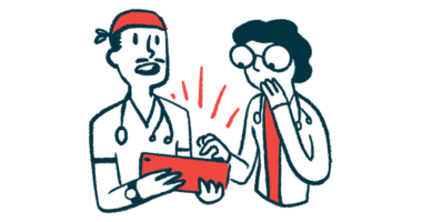 Two doctors consult with each other while looking at a tablet.